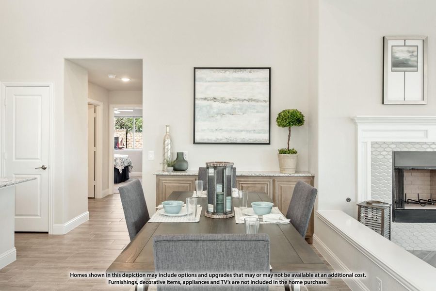 Dining room with wood table, gray chairs, buffet cabinet, and white tile fireplace Dining room with wood table, gray chairs, buffet cabinet, and white tile fireplace