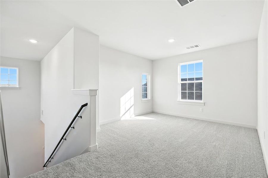 Empty room featuring carpet flooring, healthy amount of natural light, and recessed lighting Empty room featuring carpet flooring, healthy amount of natural light, and recessed lighting