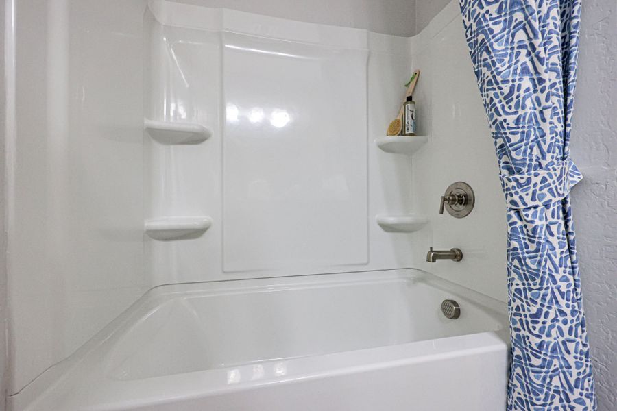 A bathtub with a shower curtain.