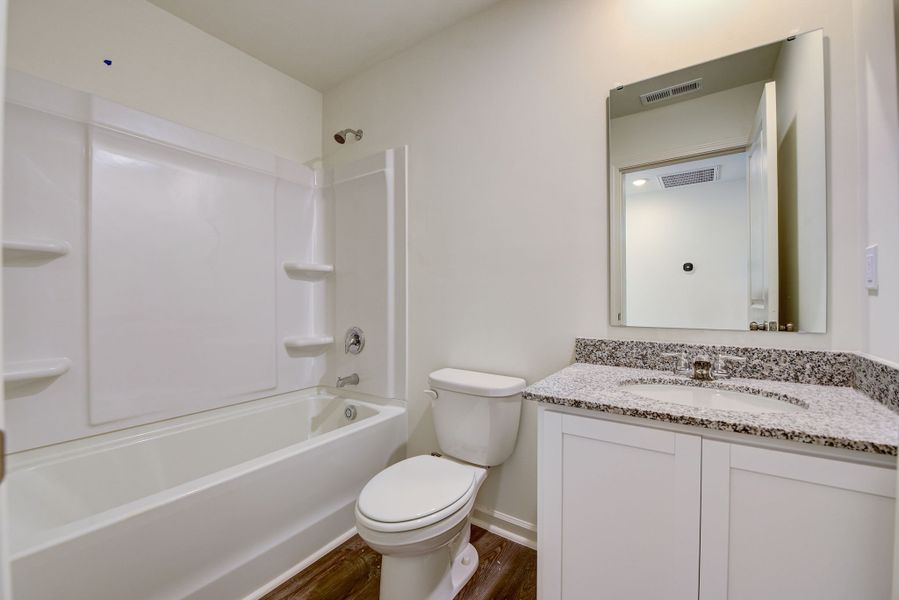 A bathroom with a tub toilet and sink.