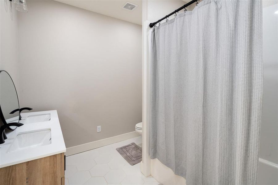 Bathroom featuring tile patterned flooring, vanity, and toilet