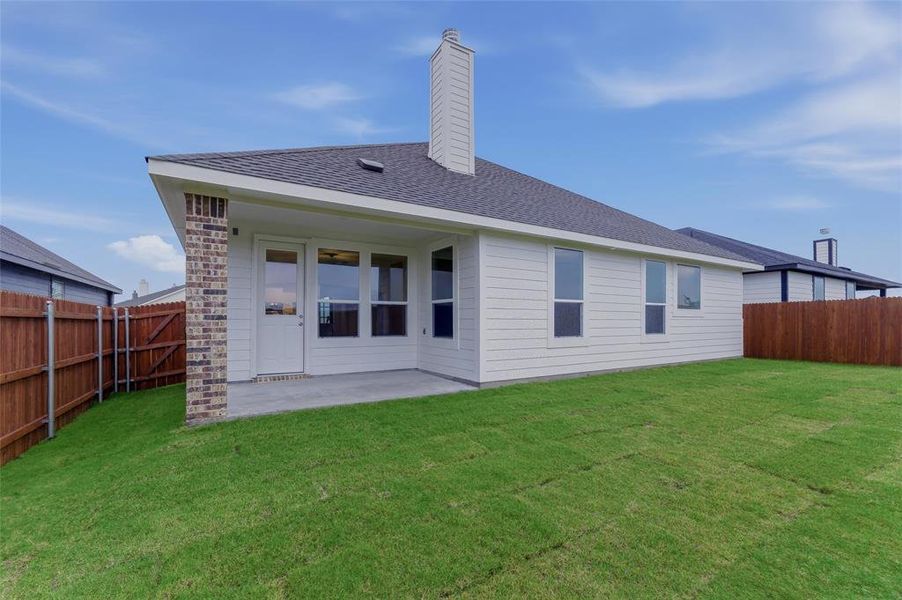 Expansive backyard with a covered concrete patio, new sod, and privacy fencing Expansive backyard with a covered concrete patio, new sod, and privacy fencing