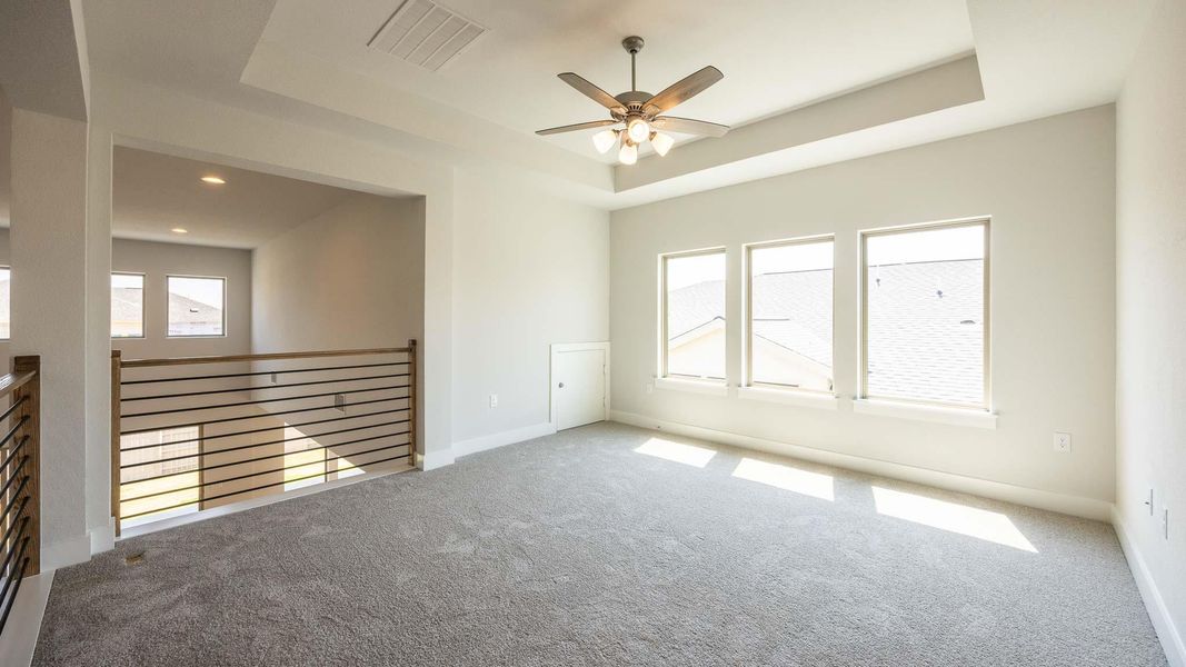 Carpeted spare room with a raised ceiling, ceiling fan, and baseboards Carpeted spare room with a raised ceiling, ceiling fan, and baseboards