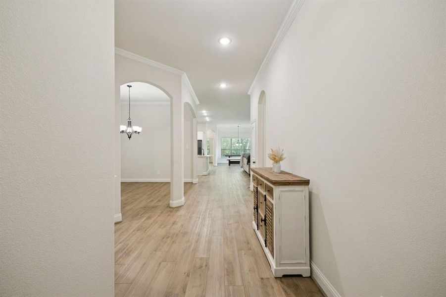 Entryway featuring arched walkways, crown molding, luxury vinyl plank flooring, and recessed lighting.