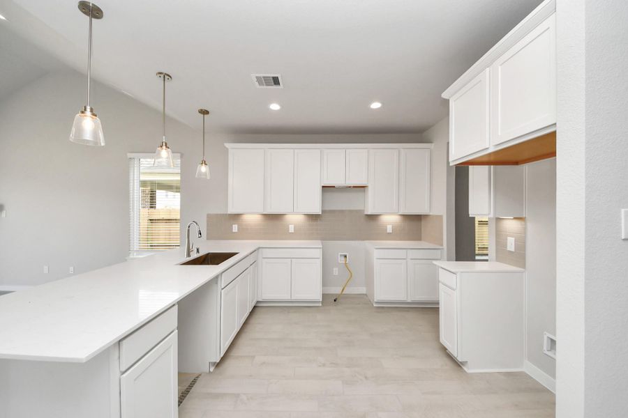 The kitchen is a culinary haven, featuring granite countertops, a tile backsplash, stainless steel appliances, 42” upper cabinets, and undercabinet lighting.