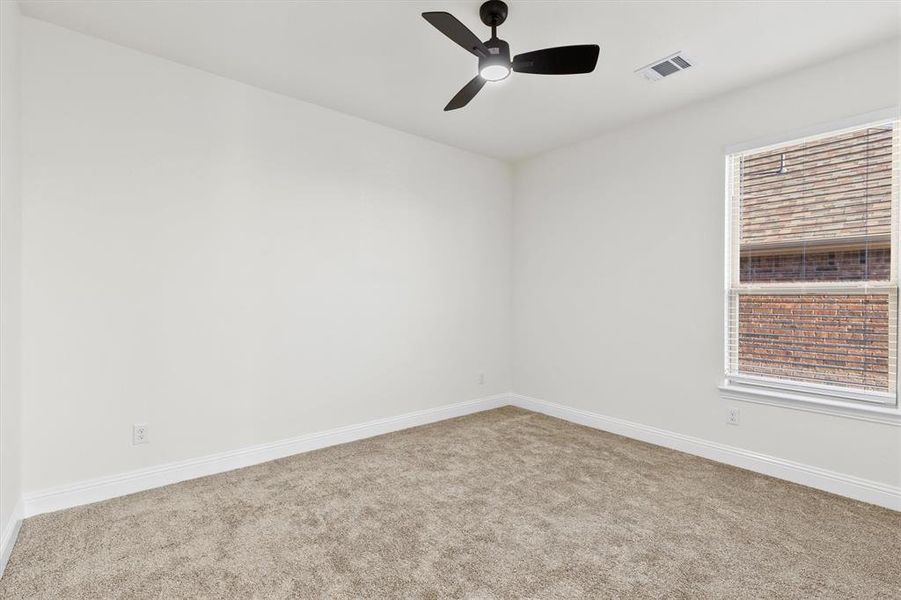 Empty room with carpet floors, a wealth of natural light, visible vents, and baseboards Empty room with carpet floors, a wealth of natural light, visible vents, and baseboards