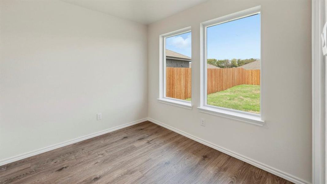 Unfurnished room with wood finished floors and baseboards Unfurnished room with wood finished floors and baseboards