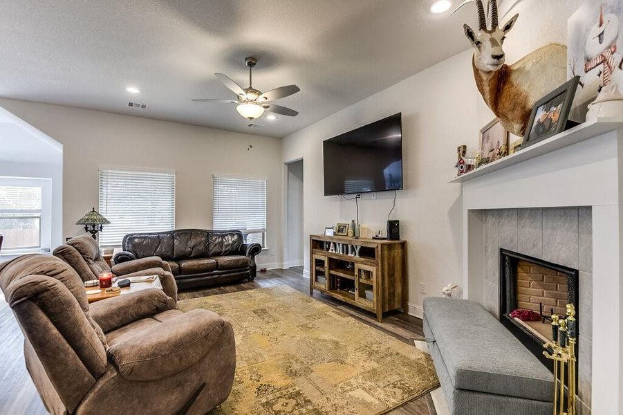 The living room features high ceilings, LVP flooring and a cozy wood burning fireplace!