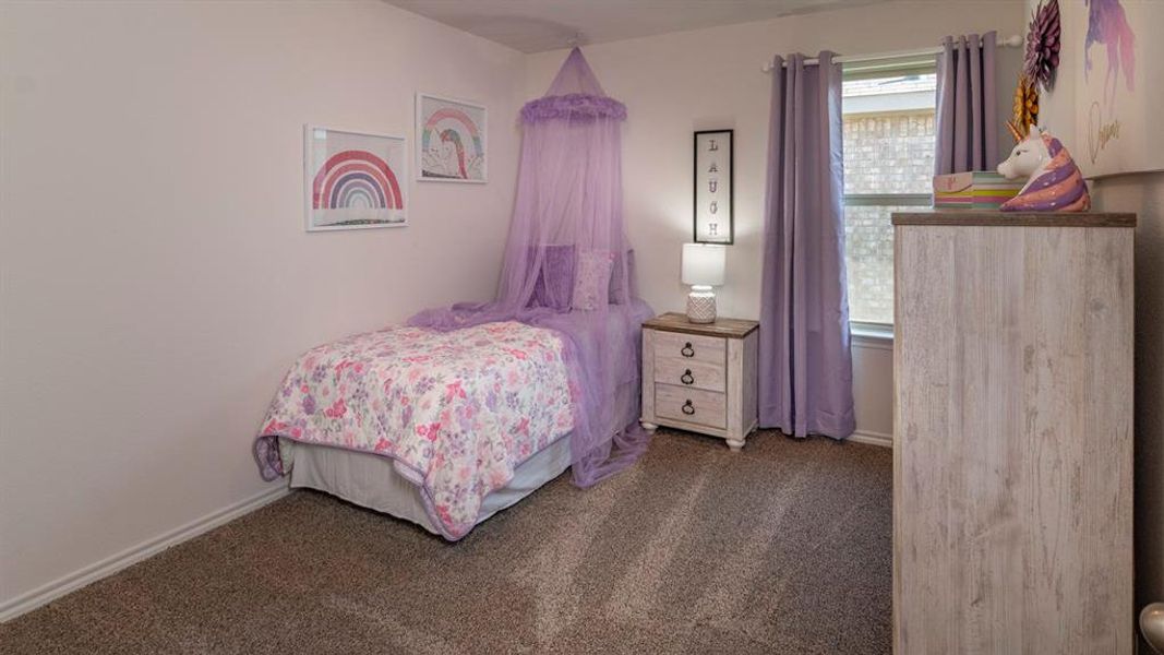 Bedroom with dark carpet and baseboards