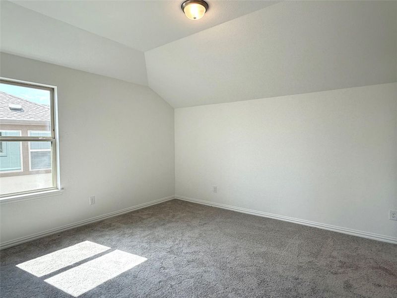 Bonus room featuring lofted ceiling and carpet Bonus room featuring lofted ceiling and carpet