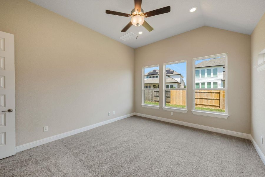 Empty room featuring carpet flooring, vaulted ceiling, a ceiling fan, and recessed lighting