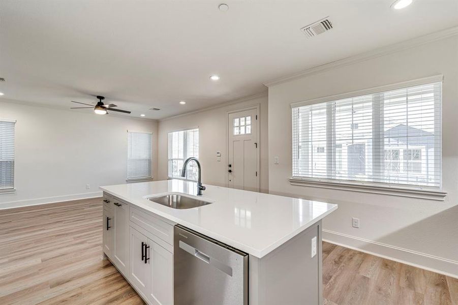 Kitchen featuring light wood-style flooring, a sink, visible vents, dishwasher, and a ceiling fan Kitchen featuring light wood-style flooring, a sink, visible vents, dishwasher, and a ceiling fan