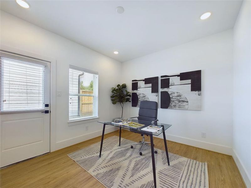 This is a bright, secondary bedroom located on the first floor. Windows for natural light, and a door leading to the yard, offer a clean canvas for personalization.