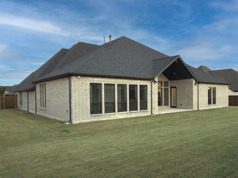 Back of property with a patio area, brick siding, and roof with shingles Back of property with a patio area, brick siding, and roof with shingles