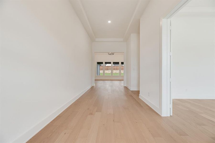 Corridor with light wood-style flooring and recessed lighting