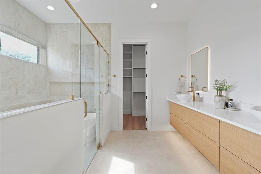 Full bathroom featuring a stall shower, double vanity, a spacious closet, light tile patterned flooring, and recessed lighting Full bathroom featuring a stall shower, double vanity, a spacious closet, light tile patterned flooring, and recessed lighting