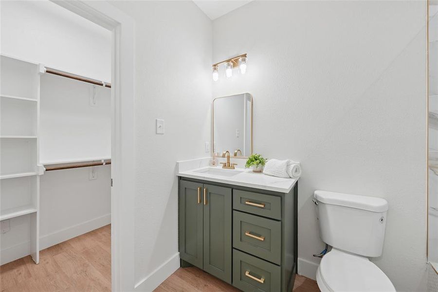 Bathroom with light wood-type flooring, vanity, and a spacious closet Bathroom with light wood-type flooring, vanity, and a spacious closet