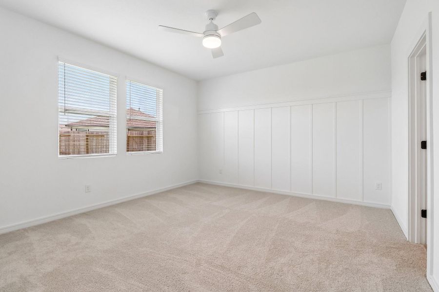 Spacious primary suite with decorative feature wall