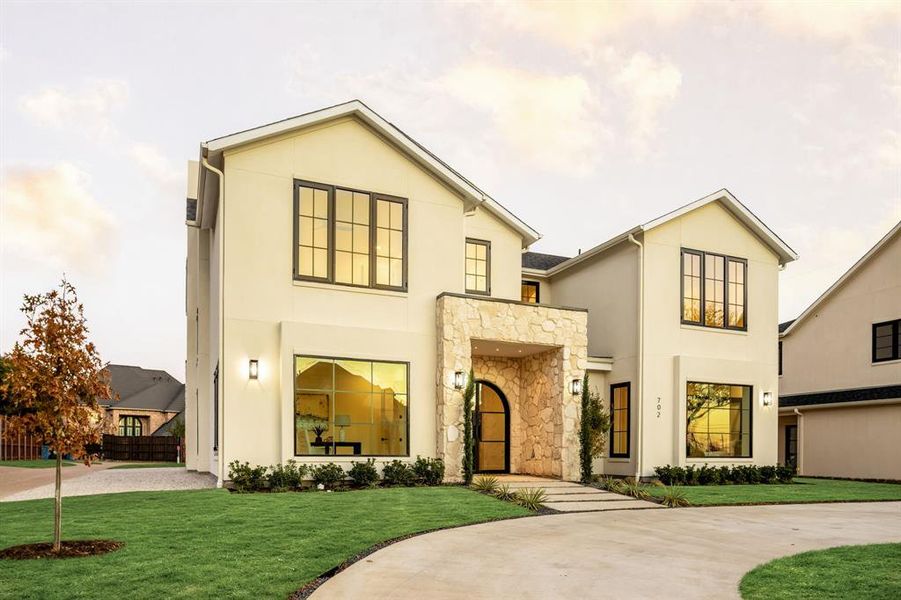 View of front of home featuring curved driveway, stucco siding, and stone siding View of front of home featuring curved driveway, stucco siding, and stone siding