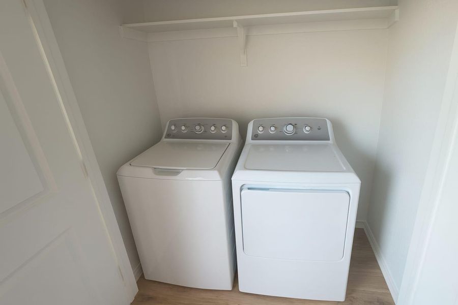 Laundry room featuring washer and dryer and light wood finished floors Laundry room featuring washer and dryer and light wood finished floors