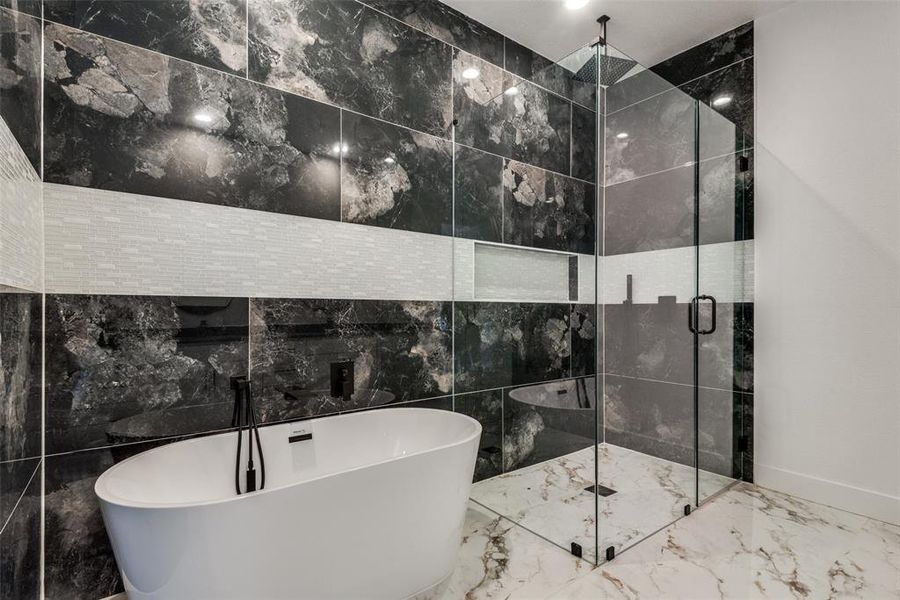 Bathroom with a shower stall, a soaking tub, and marble finish floor