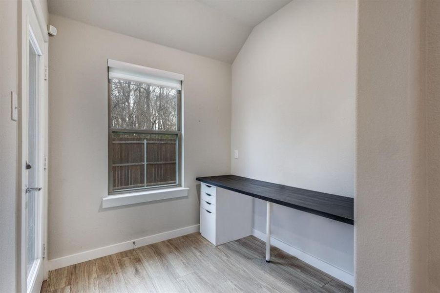 Unfurnished office with lofted ceiling and light wood-style flooring Unfurnished office with lofted ceiling and light wood-style flooring