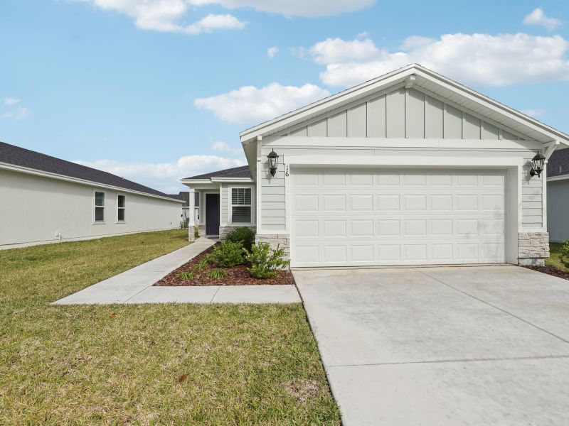Front exterior of a new home in Flagler Village - Classic Series, Palm Coast, FL, highlighting curb appeal (Image 1). Front exterior of a new home in Flagler Village - Classic Series, Palm Coast, FL, highlighting curb appeal (Image 1).