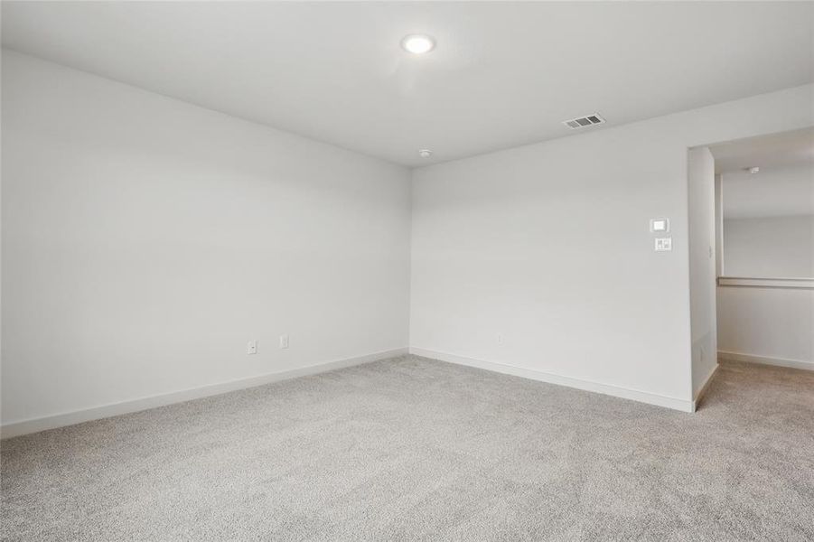 Empty room featuring baseboards, visible vents, and carpet flooring Empty room featuring baseboards, visible vents, and carpet flooring