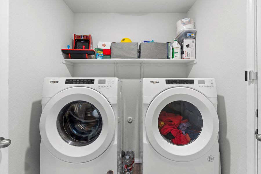 A dedicated laundry space provides optimal convenience with side-by-side appliances and overhead shelving. A dedicated laundry space provides optimal convenience with side-by-side appliances and overhead shelving.