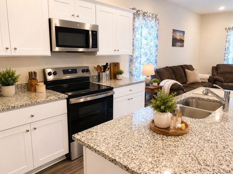 Beautiful kitchen featuring granite countertops, stainless steel appliances, abundant cabinetry, and a large center island with seating, all overlooking the main living area Beautiful kitchen featuring granite countertops, stainless steel appliances, abundant cabinetry, and a large center island with seating, all overlooking the main living area