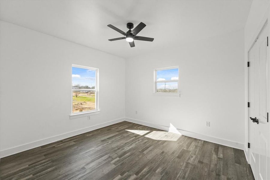 Unfurnished room featuring ceiling fan and dark hardwood / wood-style flooring