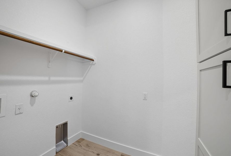 Washroom with light wood finished floors, electric dryer hookup, and hookup for a gas dryer Washroom with light wood finished floors, electric dryer hookup, and hookup for a gas dryer