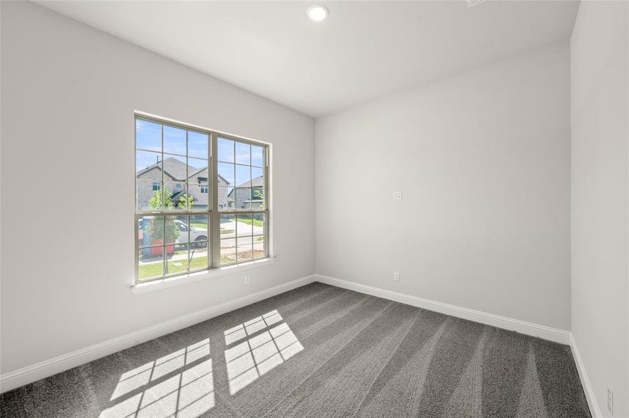 Carpeted empty room with recessed lighting and a residential view