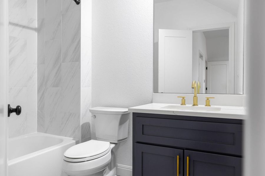 Full bath featuring vanity, a textured wall, and shower / bathtub combination Full bath featuring vanity, a textured wall, and shower / bathtub combination