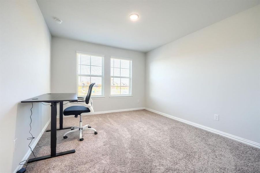 Unfurnished office with light carpet and baseboards Unfurnished office with light carpet and baseboards