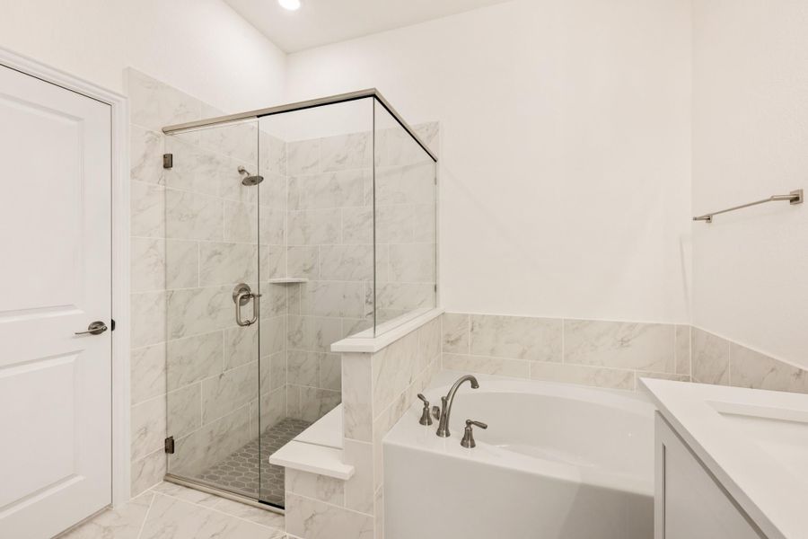Bathroom with glass-enclosed walk-in shower, soaking tub, and marble tile walls and floors Bathroom with glass-enclosed walk-in shower, soaking tub, and marble tile walls and floors