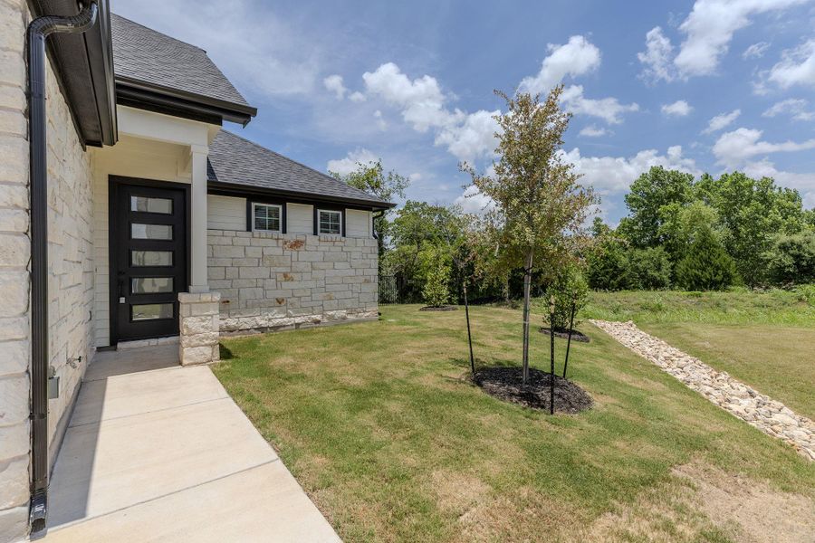 A striking modern black entry door contrasts with a light stone and siding facade, offering a welcoming approach to this property. A striking modern black entry door contrasts with a light stone and siding facade, offering a welcoming approach to this property.