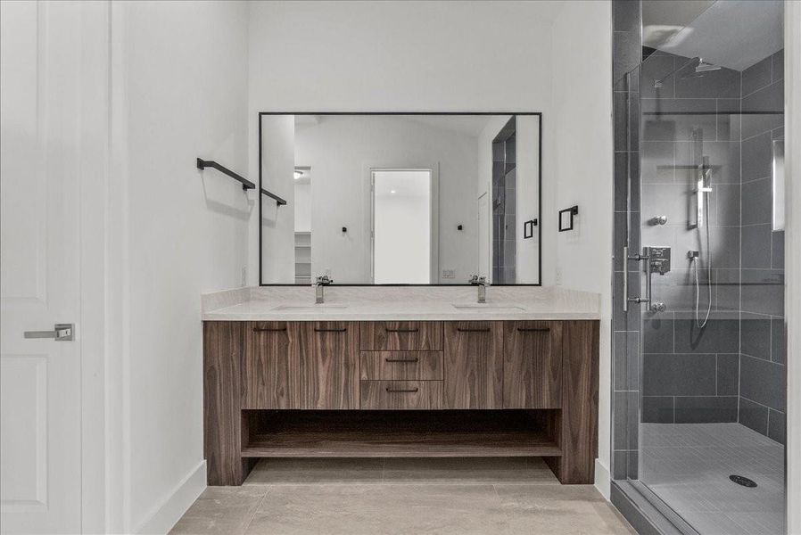 The guest suite bathroom offers a stunning dual-vanity setup, large shower, and huge walk in closet.