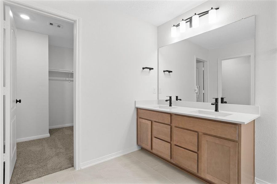 This primary bathroom is definitely move-in ready! Featuring stained cabinets with light countertops, dual vanities, walk-in closet, high ceilings, neutral paint, sleek and modern finishes.