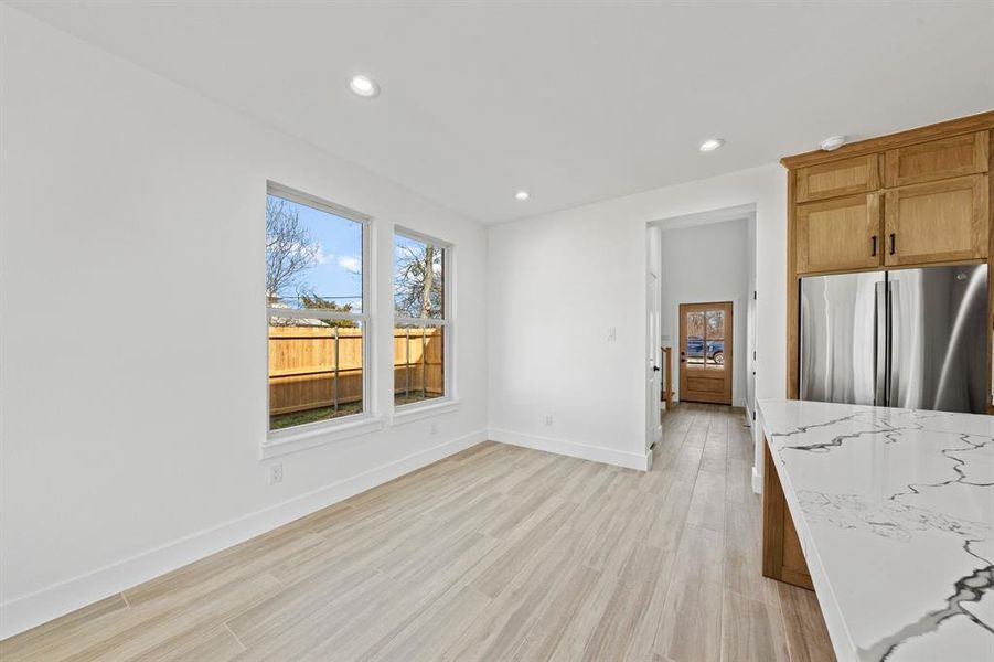 Kitchen featuring light wood-style floors, recessed lighting, baseboards, and freestanding refrigerator