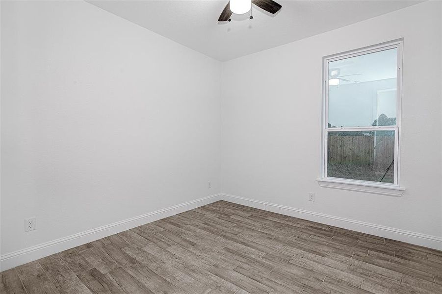 Spare room featuring a ceiling fan, wood finished floors, and baseboards Spare room featuring a ceiling fan, wood finished floors, and baseboards
