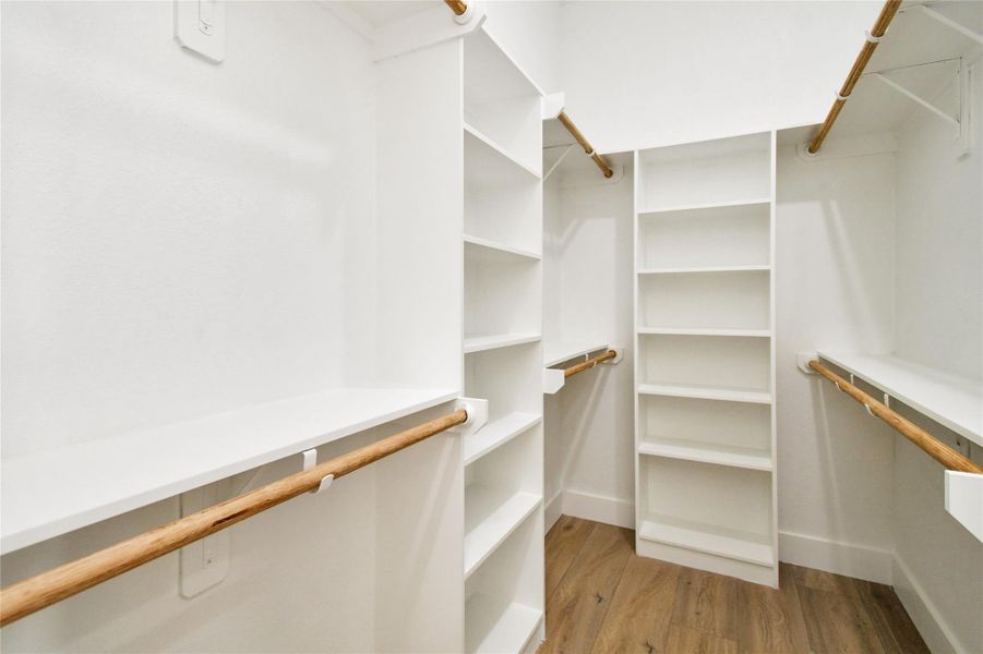 The massive walk-in closet is fully equipped with custom built-in shelving and hanging rods for ultimate organization.
