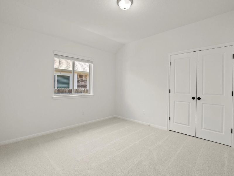 Neutral color palette room featuring light-toned carpeting, a window with horizontal blinds, and a flush-mount ceiling light fixture