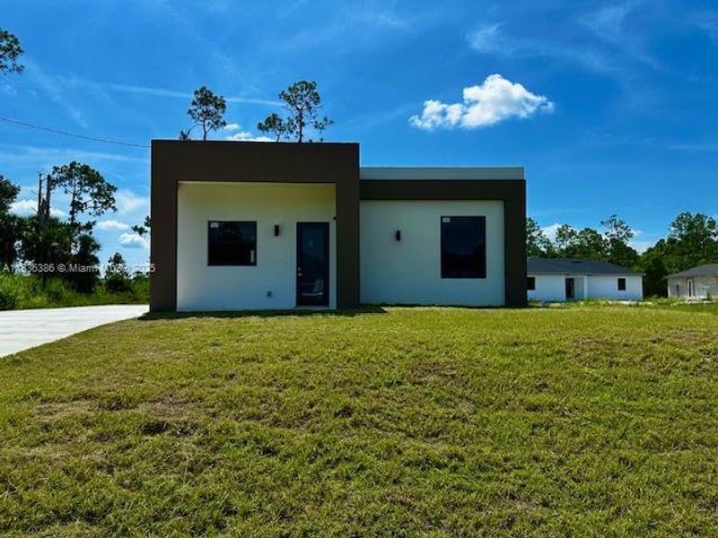 Front exterior of a new home in , Lehigh Acres, FL, highlighting curb appeal (Image 1).