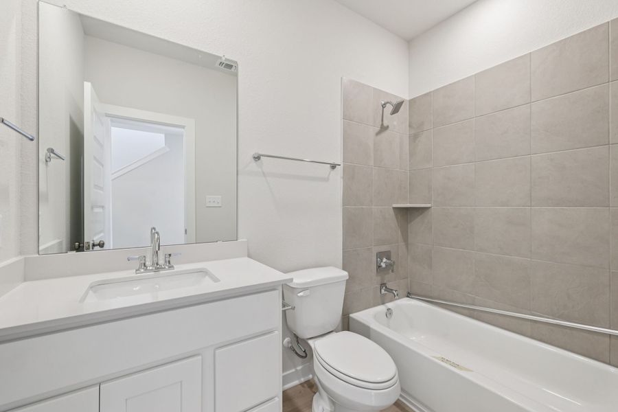 A bathroom with a tub sink and toilet.