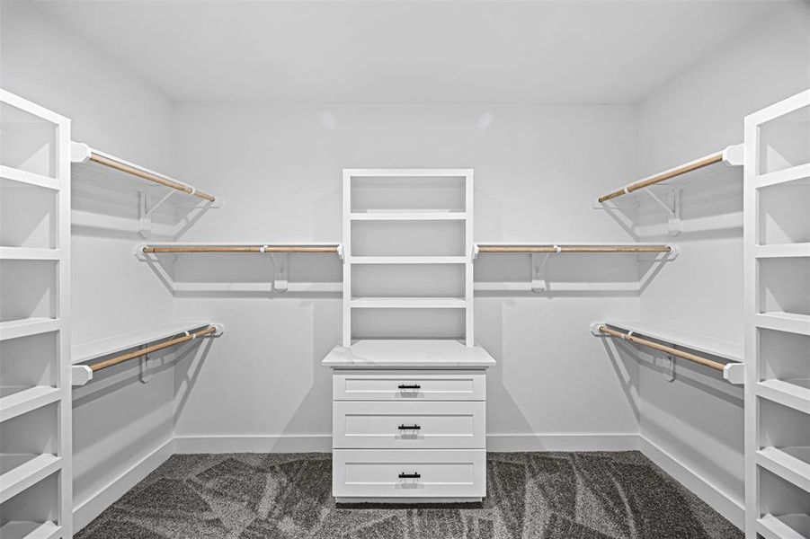 Oversized walk-in closet with built in shelves and granite details