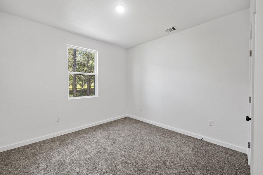 A well-lit bedroom features plush carpeting, creating a comfortable and inviting atmosphere. A well-lit bedroom features plush carpeting, creating a comfortable and inviting atmosphere.