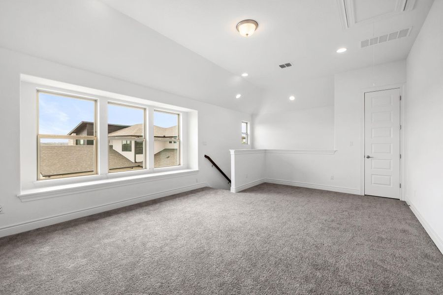 Carpeted empty room with attic access, recessed lighting, and vaulted ceiling
