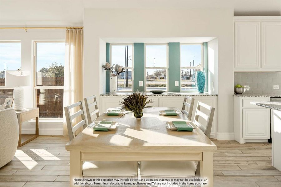 Bright dining area with wood table, white chairs, large windows, and open view to white kitchen with granite counters. Bright dining area with wood table, white chairs, large windows, and open view to white kitchen with granite counters.