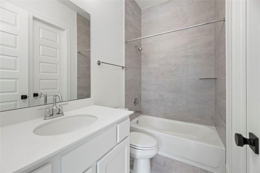 Bathroom 3 features a shower/tub combination with upgraded bathroom tile to the ceiling.
